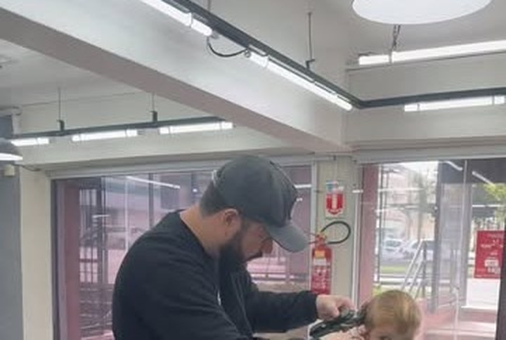 Barbeiro atendendo criança dentro da ReZenha Barbearia